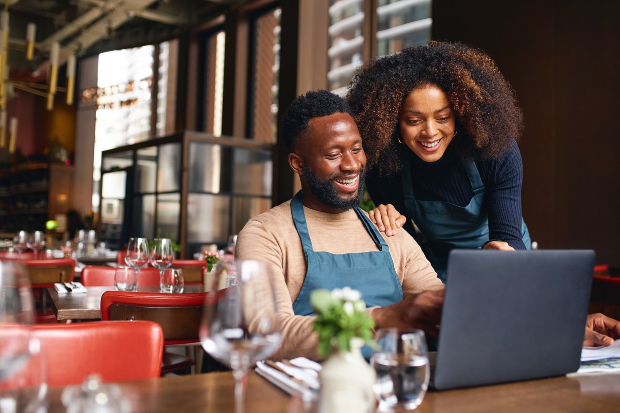 Small Business Owners Using Laptop in Restaurant